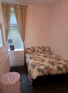 Cozy double bedroom featuring a colorful floral...