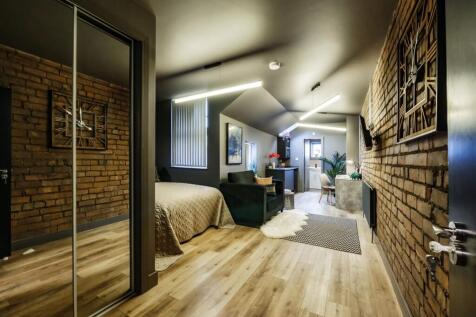 A stylish, spacious master bedroom featuring ex...