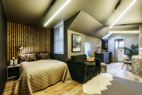 A stylish and spacious master bedroom featuring...