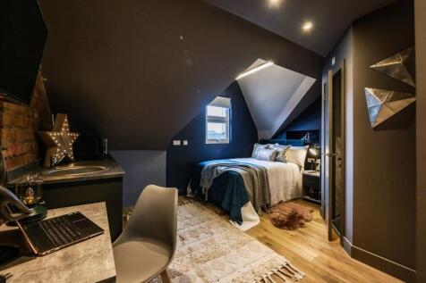 A stylish and cozy attic master bedroom featuri...