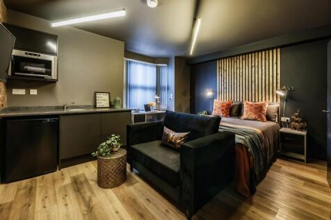 A stylish and modern master bedroom featuring a...