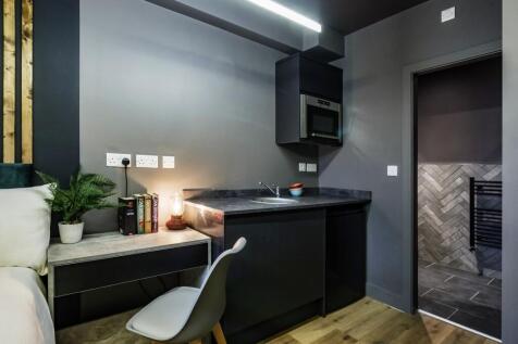 Modern compact kitchen area featuring sleek bla...