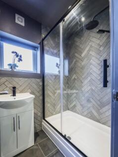 A modern bathroom featuring a sleek walk-in sho...