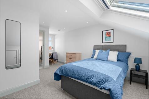 Bright and welcoming double bedroom featuring a...