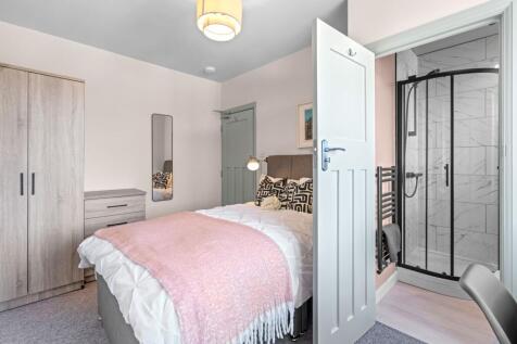 A bright and cozy master bedroom featuring a co...
