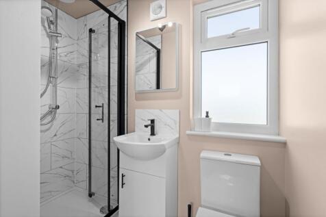 A modern bathroom featuring a sleek walk-in sho...