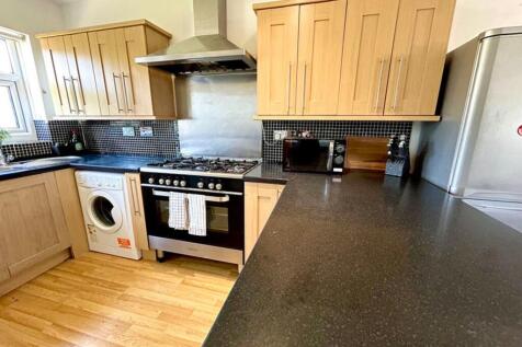 A spacious and modern kitchen featuring sleek c...