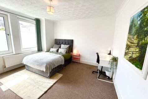 A spacious and bright double bedroom featuring ...