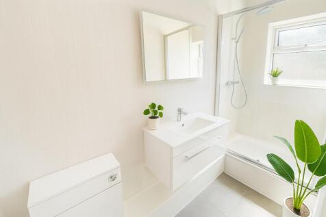 Bright and modern bathroom featuring a sleek wh...