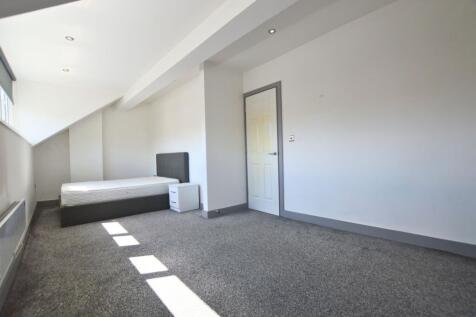 A bright single bedroom featuring a modern grey...