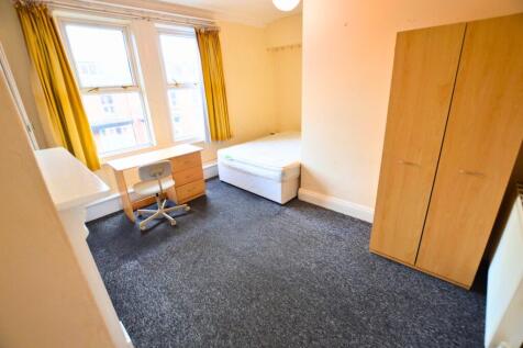 A bright and tidy single bedroom featuring two ...
