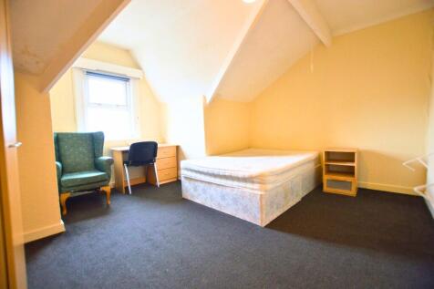 A bright double bedroom featuring a comfortable...