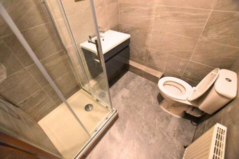 Modern bathroom featuring a glass-enclosed show...