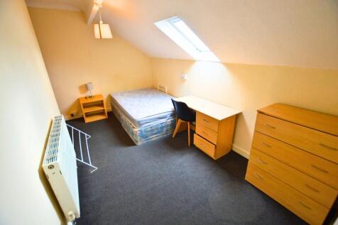 A compact attic bedroom featuring a single bed,...