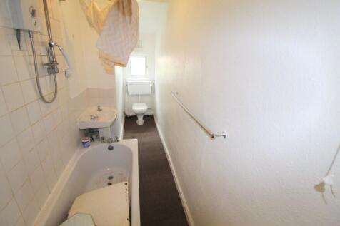 A compact bathroom suite with a bathtub, shower...