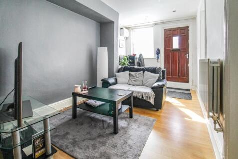 A compact living room featuring a black leather...