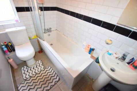 A bright, modern bathroom featuring a large whi...