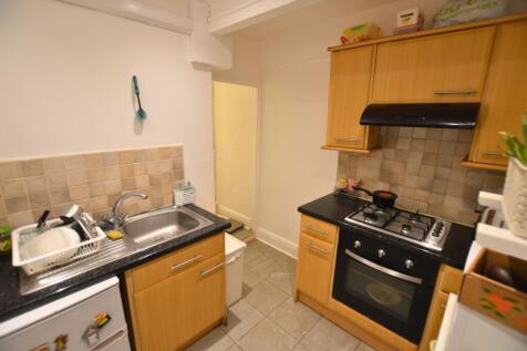 Compact kitchen featuring modern light wood cab...