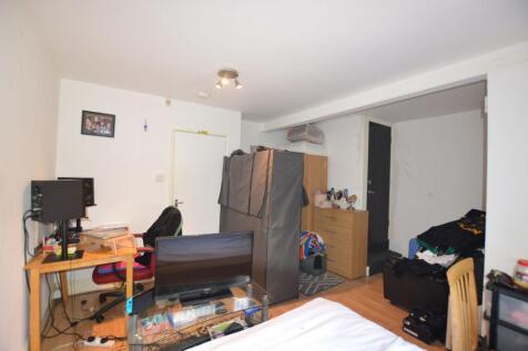 A compact bedroom featuring a work desk with au...