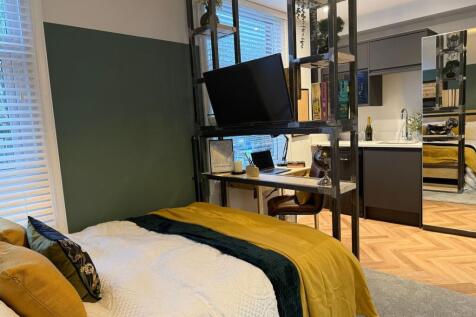A stylish master bedroom featuring a comfortabl...