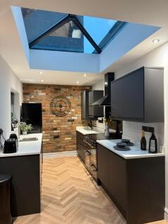 A modern kitchen featuring sleek black cabinetr...