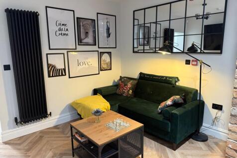A stylish living room featuring a dark green ve...