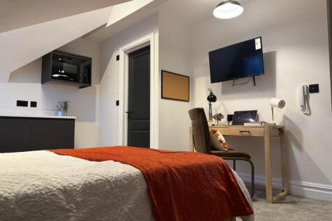 A modern and tidy double bedroom featuring a co...