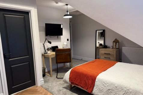 A cozy double bedroom featuring a neatly made b...