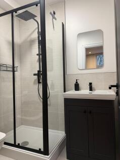 A modern bathroom featuring a sleek black-frame...