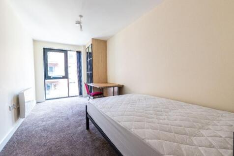 Bright and tidy bedroom featuring a large windo...