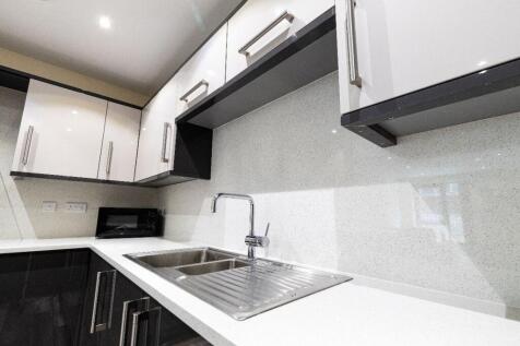 Modern kitchen featuring sleek black and white ...