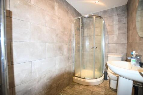 Modern bathroom featuring sleek grey tiled wall...