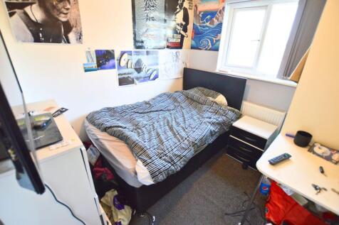 A cozy bedroom featuring a comfortable single b...