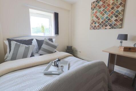 Bright and clean small bedroom featuring a neat...
