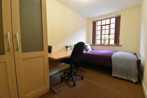 A cozy single bedroom featuring a comfortable b...