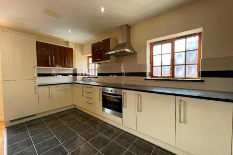 A bright, modern kitchen featuring ample counte...