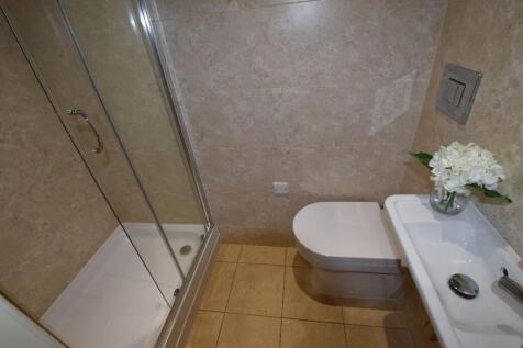 A modern bathroom featuring a glass-enclosed sh...