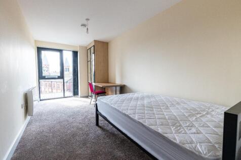 Bright single bedroom featuring a large window ...