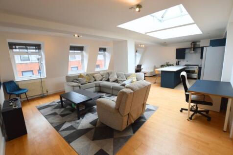 A spacious, modern living room featuring a larg...