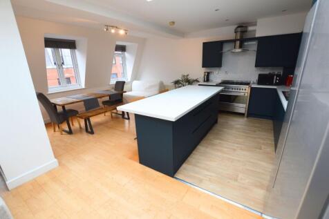 Bright and modern kitchen with sleek dark cabin...