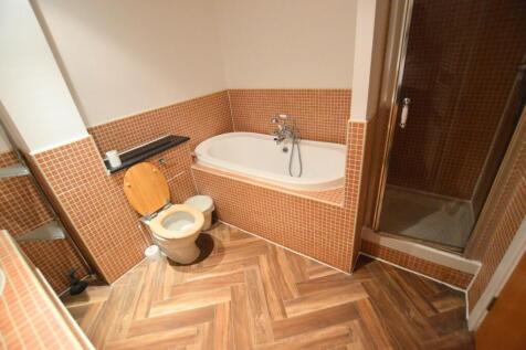 A warm-toned bathroom suite featuring a comfort...