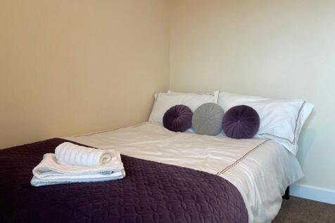 Cozy double bedroom featuring a neatly made bed...