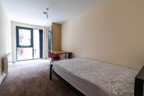 A bright and clean single bedroom featuring a w...