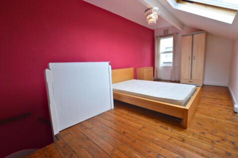 A cozy single bedroom with warm wooden flooring...