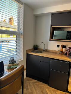 A modern, compact kitchen area featuring sleek ...