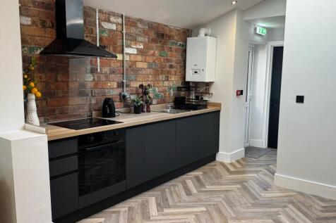 A modern kitchen featuring sleek black cabinetr...
