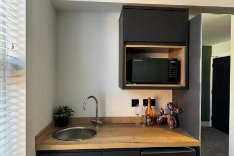 A modern kitchen area featuring a sleek wooden ...