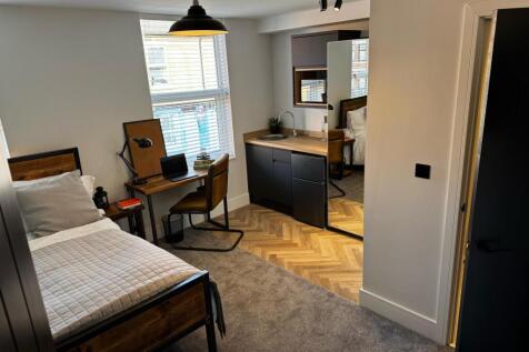 A modern, well-kept single bedroom featuring a ...