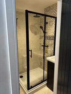 A modern bathroom featuring a stylish walk-in s...