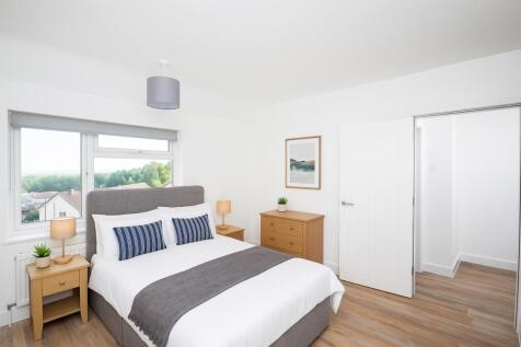 Bright and spacious master bedroom with a comfo...